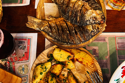 Delicious grilled fish and roasted potatoes served on a rustic wooden dining se, a Photo by AS photostudio