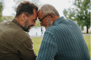 Father and adult son sharing a, a Person Photo by HalfPoint