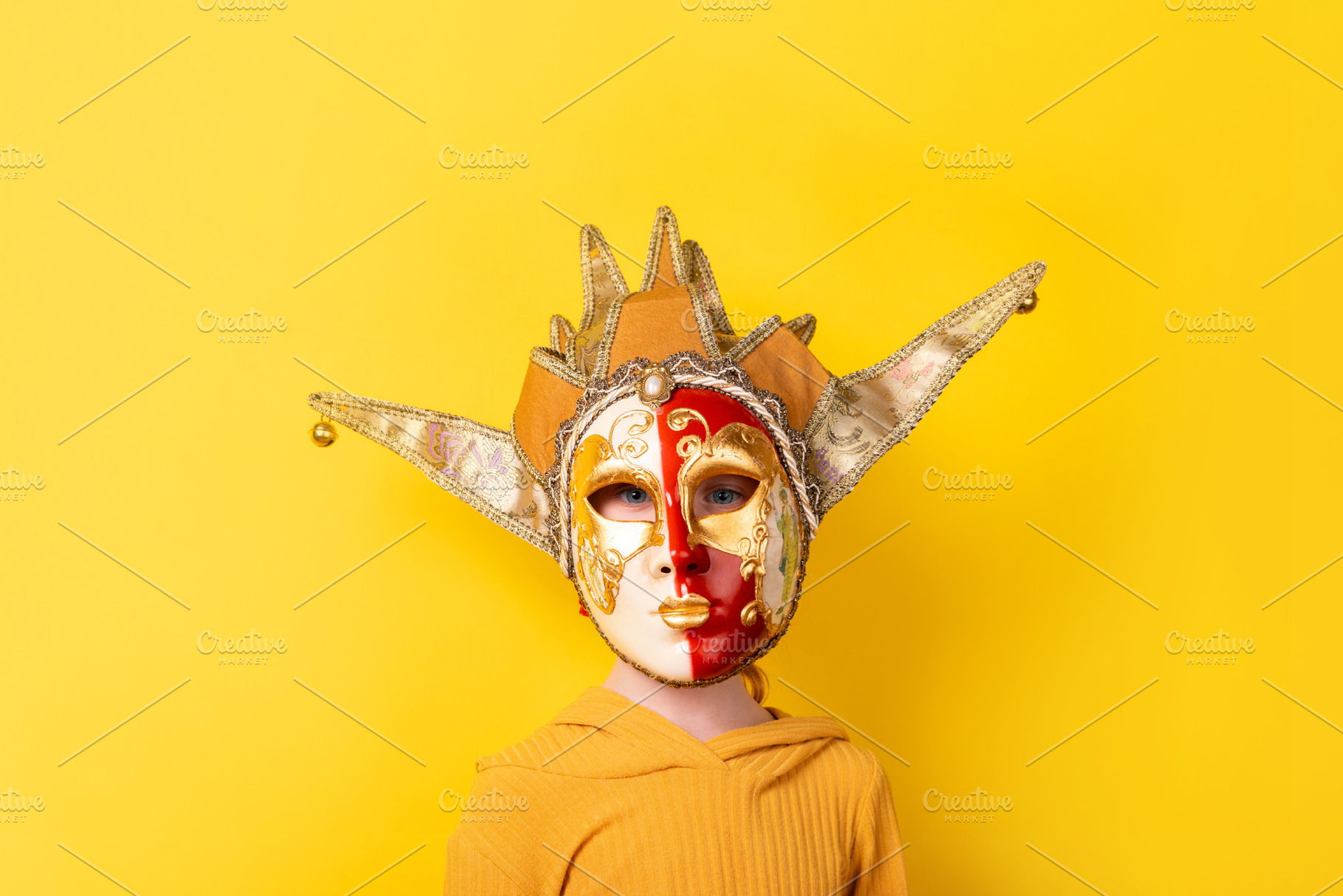 Young child wearing a colorful Venetian carnival mask against a, a Person Photo by Ales Munt