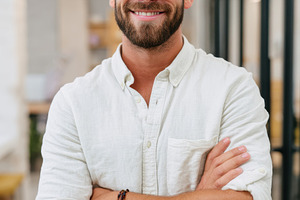 Smiling young man in modern office setting, a Business Photo by AlyaAnd