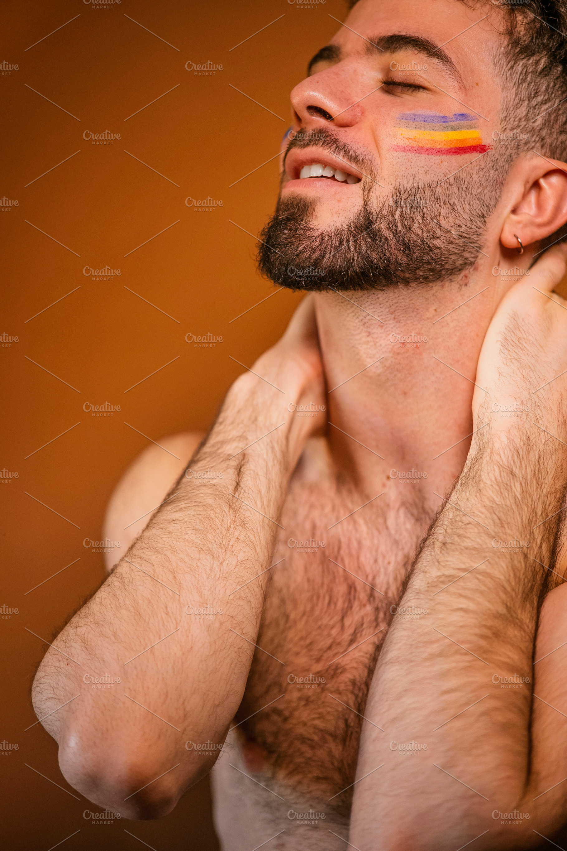 Person feeling pride with rainbow flag face paint, a Photo by karrastock