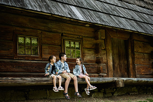 Children Sitting on Wooden Bench Near Rustic Cabin in Outdoor Setting, a Person Photo by AS photostudio