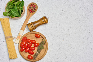 A flat lay shot of a wooden bowl with spinach, cherry tomatoes o, a Food & Drink Photo by ndanko