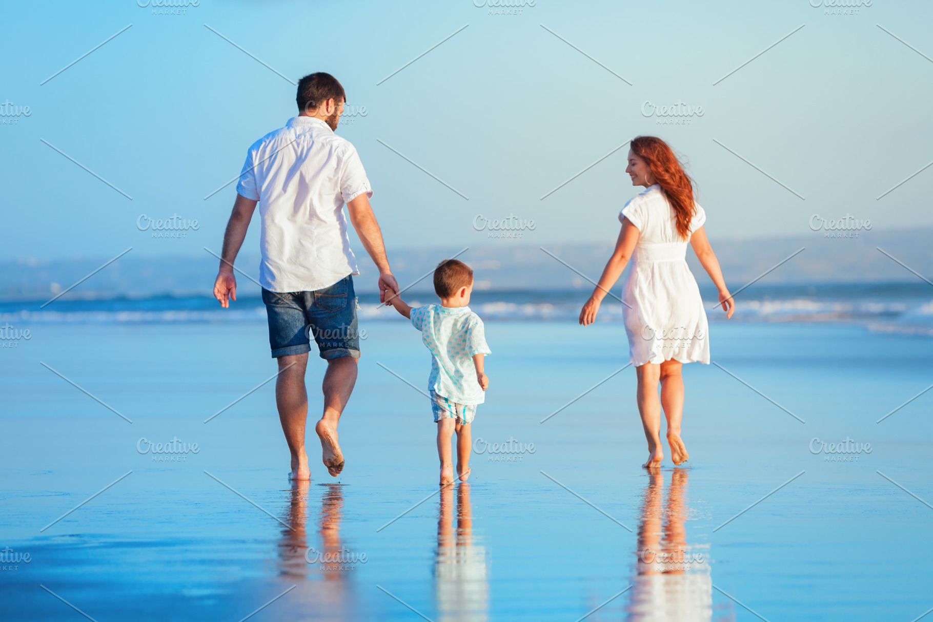 Family walking by sunset beach, a Person Photo by Tropical Studio