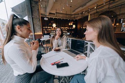 A group of women friends in a cafe working on a project