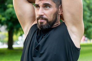 Athletic Man Stretching Triceps Before an Outdoor Workout in a Park, a Sports & Recreation Photo by etorres69