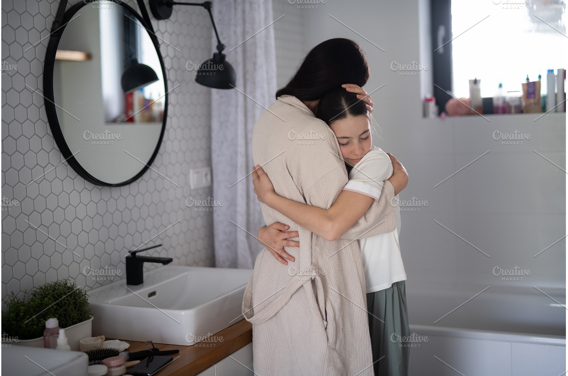 Mom hugging daughter during, a Person Photo by HalfPoint
