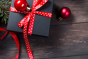 Black christmas gift box with red ribbon and fir branches, a Holiday Photo by vimart