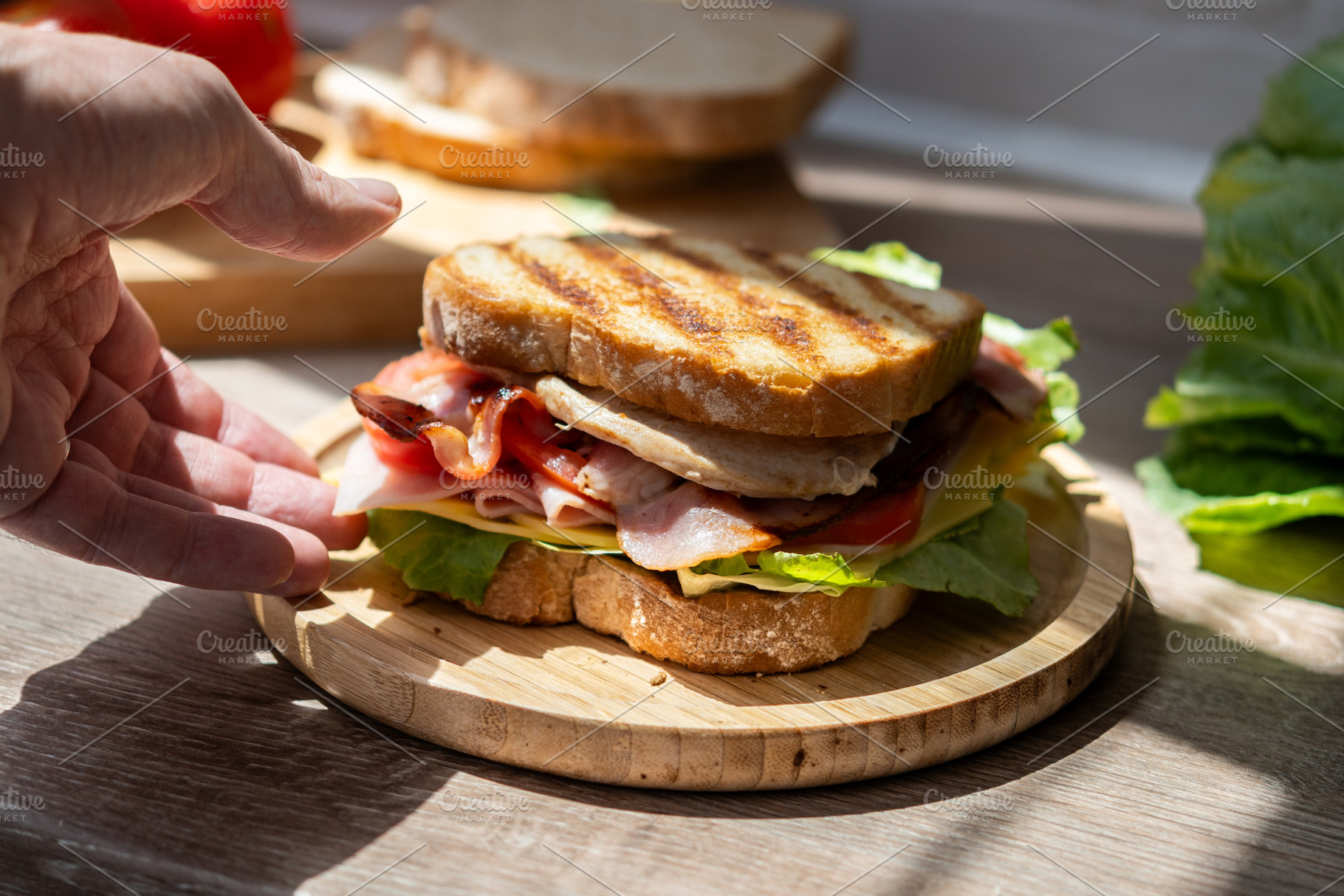 Hand picking up freshly made club sandwich, a Food & Drink Photo by etorres69