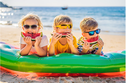 Children eat watermelon on the beach, a Person Photo by Elizaveta Galitskaya