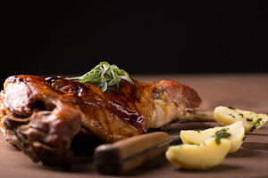 Roasted lamb leg containing animal, bone, and dinner
