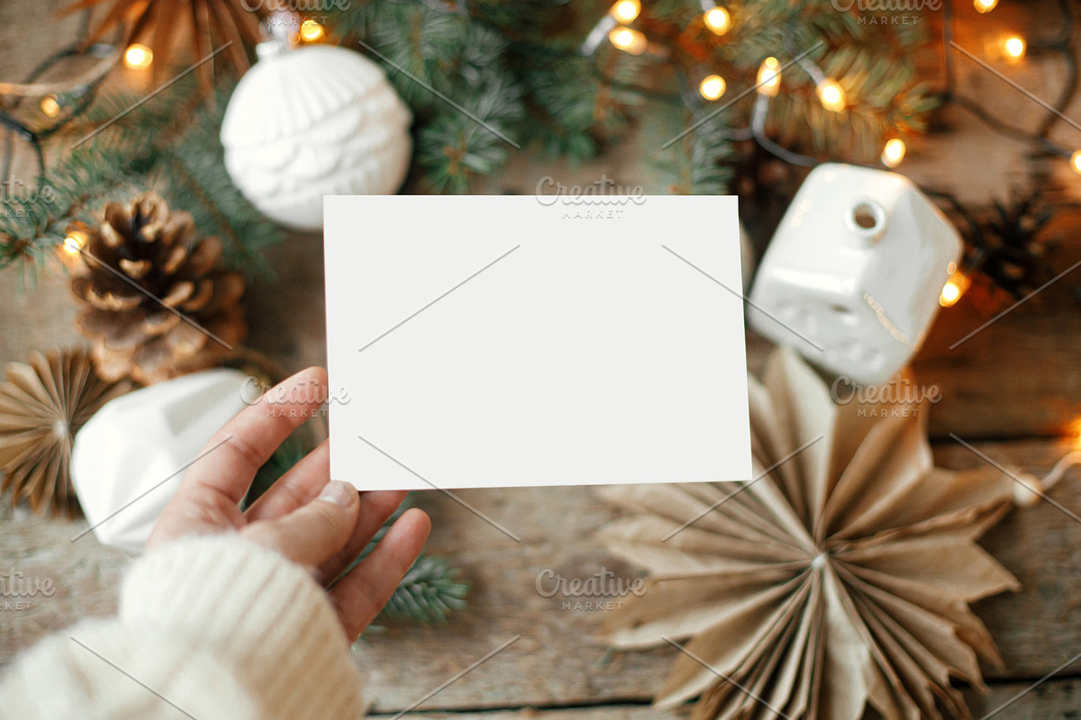 Hand holding empty greeting card at christmas stars, baubles, co, a Card Template by Sonjachni
