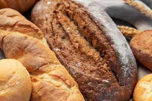 Freshly baked bread assortment with wheat ears on rustic backgro, a Food & Drink Photo by Olena Rudo