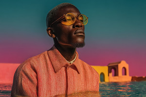 Stylish African Man in Orange Shirt Standing in Water at Colorfu, a Person Photo by José Manuel Gelpi