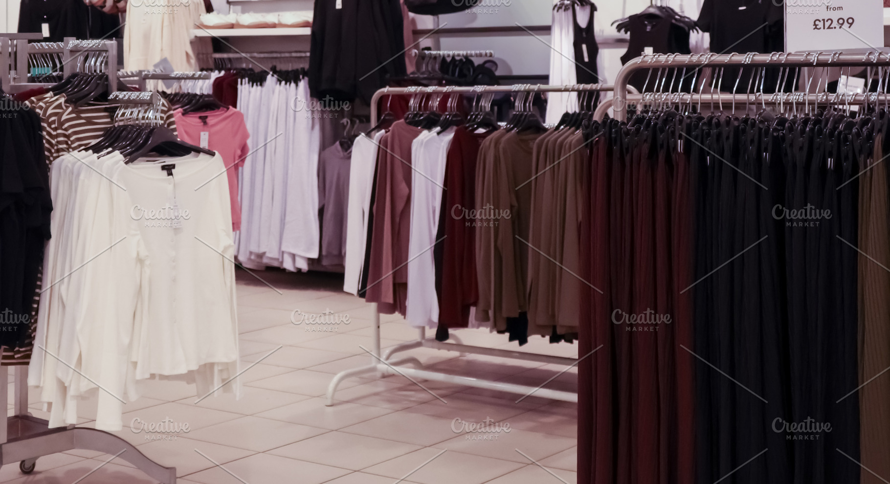 Rows of clothing on hangers in a retail store, showing different styles and col, a Photo by Studio ANNA