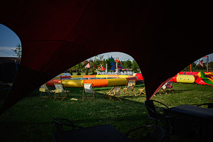 Outdoor seating around inflatable play area during vibrant summer day festival, a Photo by AS photostudio