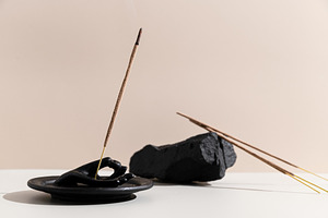 Incense sticks on a round black stan, a Photo by Edalin's Store