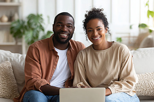 Couple enjoying quality time together while working on a laptop at home, a Photo by AlyaAnd
