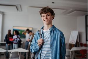 Confident teen student in classroom, a School & Education Photo by HalfPoint