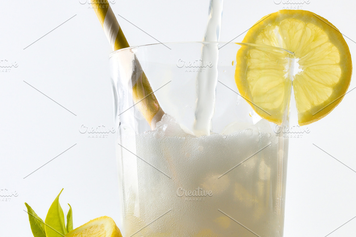 Filling glass with lemon soda decorated with straw and lemon, a Food & Drink Photo by Davizro's Market (Photo 2 of 2)