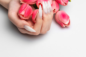 Woman's hands with long white nails holding tulips, a Beauty & Fashion Photo by Olena Rudo