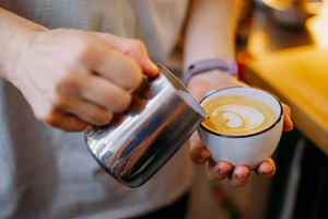 Latte art coffee shop barista hand pouring milk, a Food & Drink Photo by Photo Drive Studio