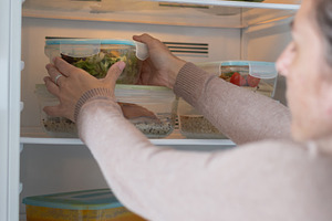 Woman Storing Healthy Meal Prep Containers in Refrigerator at Home, a Food & Drink Photo by etorres69
