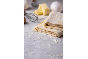 Raw puff pastry dough with baking, a Food & Drink Photo by Yulia Furman