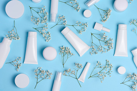 White plastic tubes, jars, and gypsophila branches on a blue bac, a Beauty & Fashion Photo by ndanko