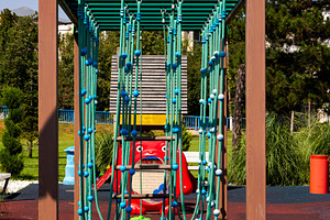 Colorful playground climbing frame with ropes and playful design in a sunny par, a Sports & Recreation Photo by Ales Munt
