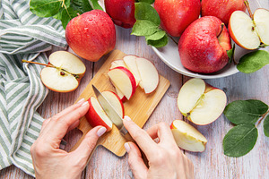 Cutting fresh red apples preparing healthy food, a Food & Drink Photo by Olena Rudo