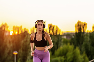 Young woman running at sunset with h, a Sports & Recreation Photo by Perpis