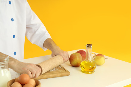 Young male chef cooking on yellow background, a Person Photo by AtlasStudio PRO