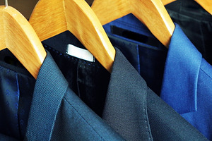 Row of men's suits hanging on rack 