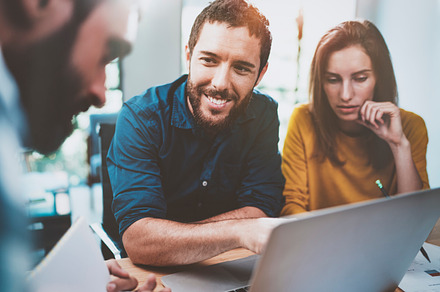 Teamwork concept.Coworking process at sunny loft office.Young Business team making conversation at meeting room.Horizontal.Blurred background.