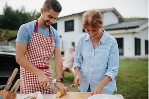 Adult son and mother preparing food, a Person Photo by HalfPoint