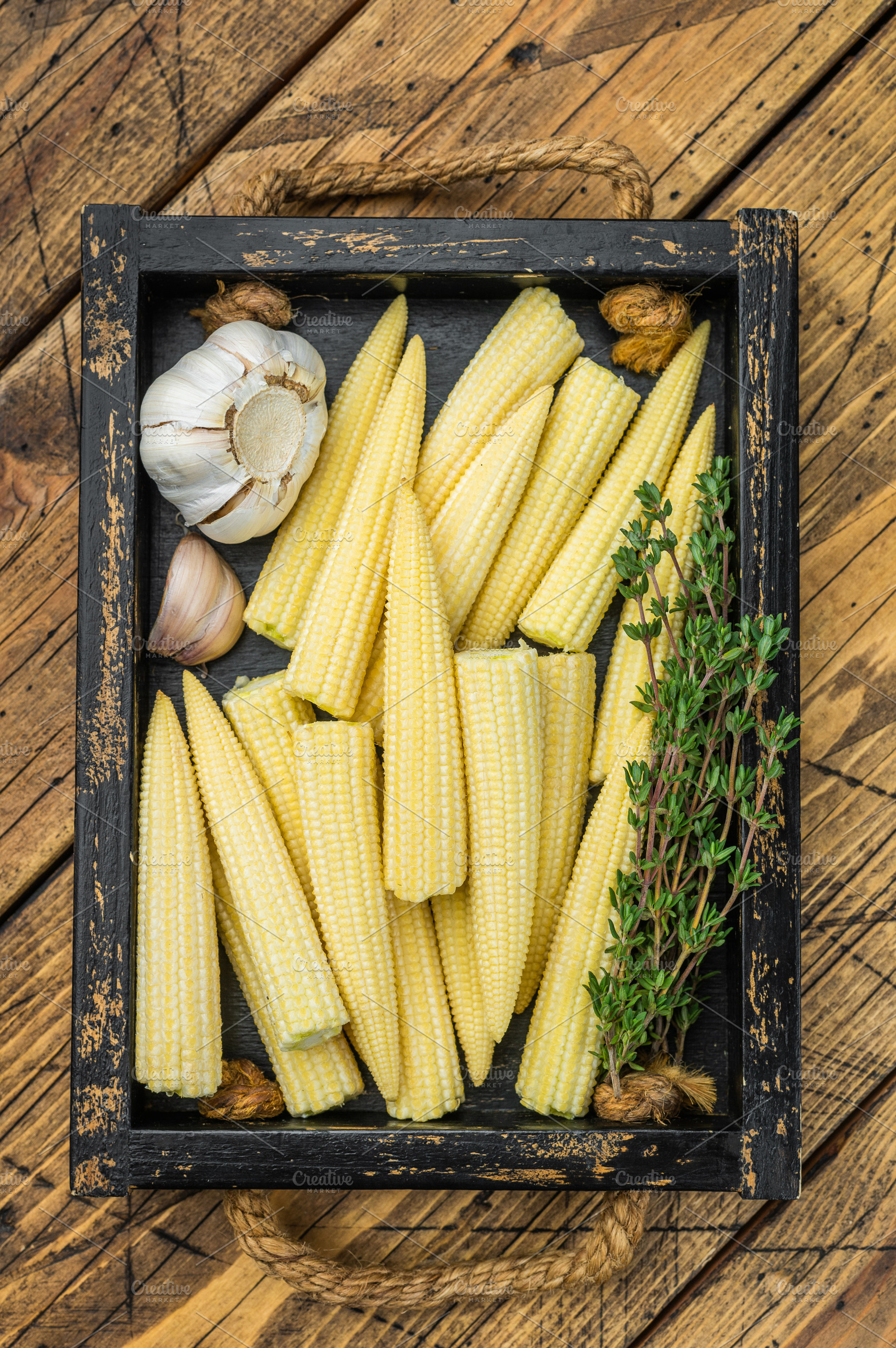 Fresh baby corn cobs in rustic wooden crate with thyme and garli, a Food & Drink Photo by composter-box@mail.ru