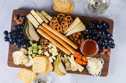 Delicious cheese mix with grapes, jam, snacks, crackers, walnuts, a Food & Drink Photo by vimart