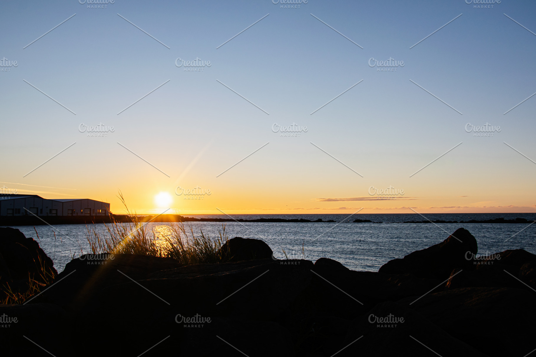 Scenic coastal sunrise view with rock foreground at Icelandic waterfront, a Nature Photo by AS photostudio