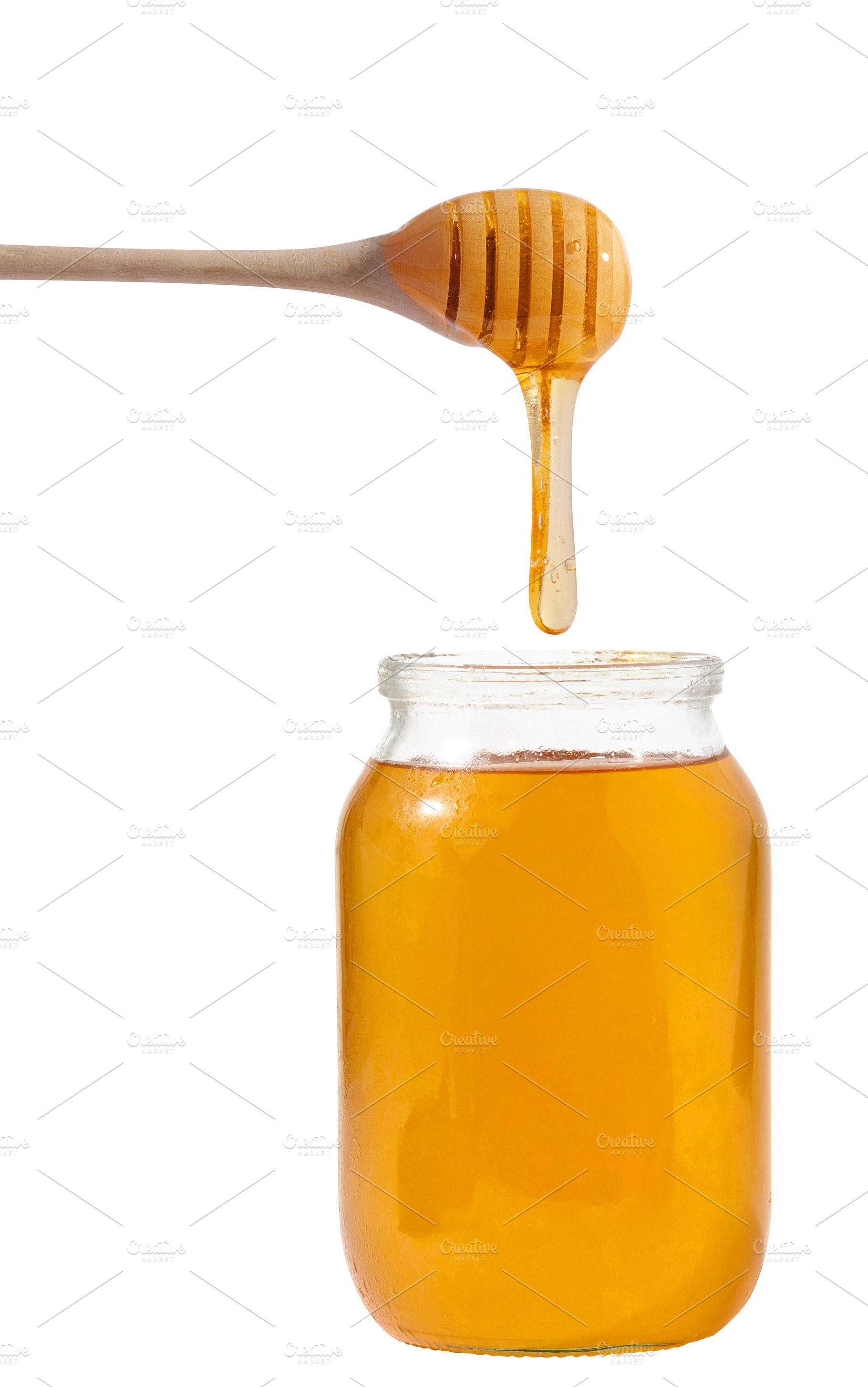 Liquid honey dripping from a wooden honey spoon into a glass jar, a Food & Drink Photo by ndanko
