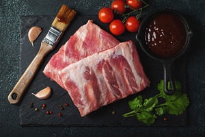 Raw meat. Raw pork ribs from the back with meat on a black background. backgrou, a Food & Drink Photo by Budarinphoto