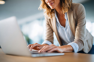 Woman working on laptop in modern office, a Business Photo by AlyaAnd