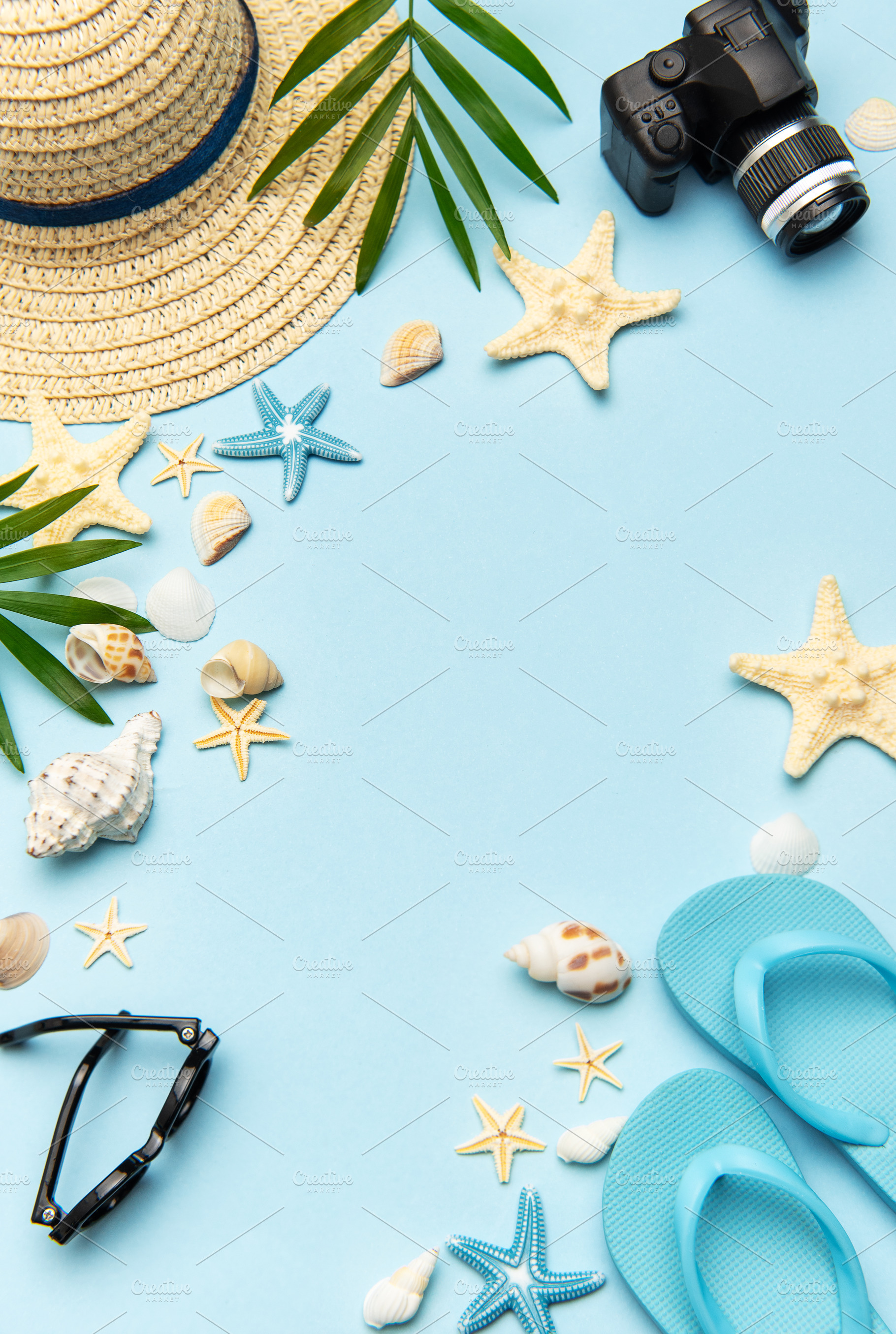 Summer accessories creating frame on light blue background with, a Holiday Photo by Olena Rudo