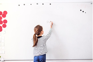 Girl student writing on whiteboard, a School & Education Photo by HalfPoint