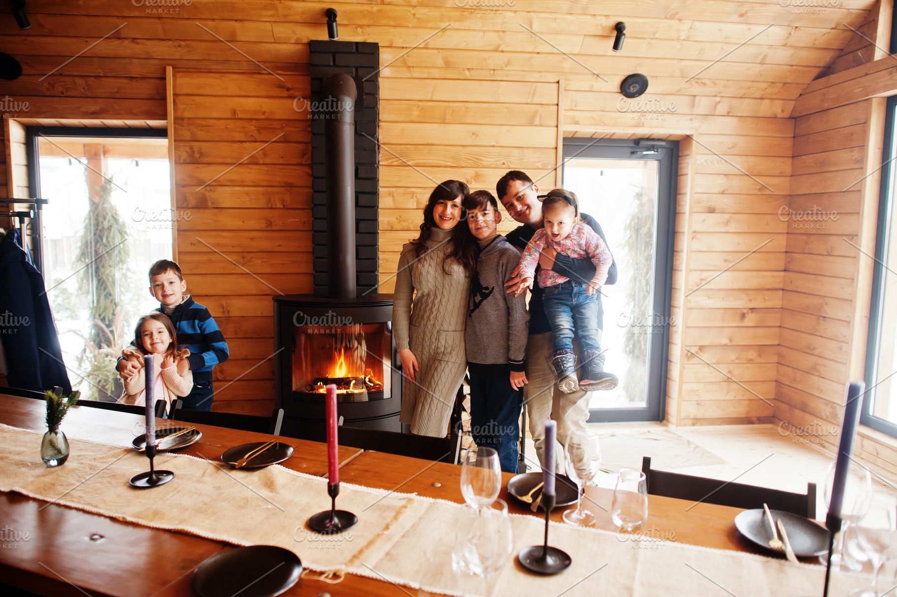 Family with four kids in modern wooden house against table and f, a Person Photo by AS photostudio