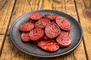 Pan-fried Turkish sucuk (sujuk) slices garnished with thyme on a, a Photo by composter-box@mail.ru