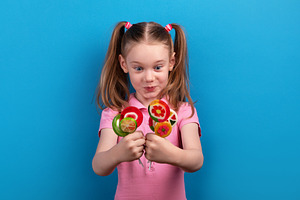 Surprised and excited young girl in a pink shirt holding colorfu, a Person Photo by Ales Munt