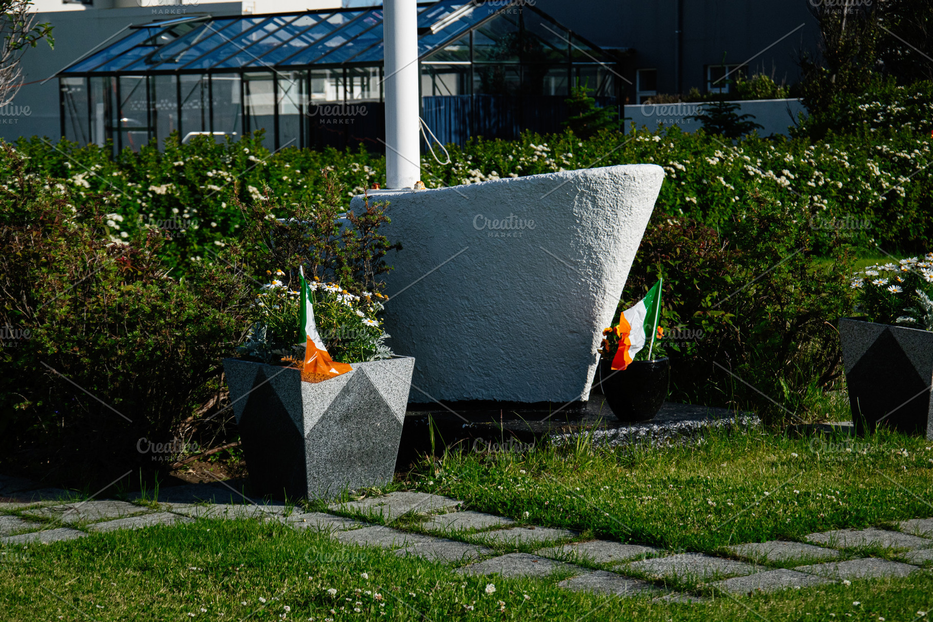 Outdoor memorial with Irish flags in Akranes, Iceland on a sunny day, a Photo by AS photostudio