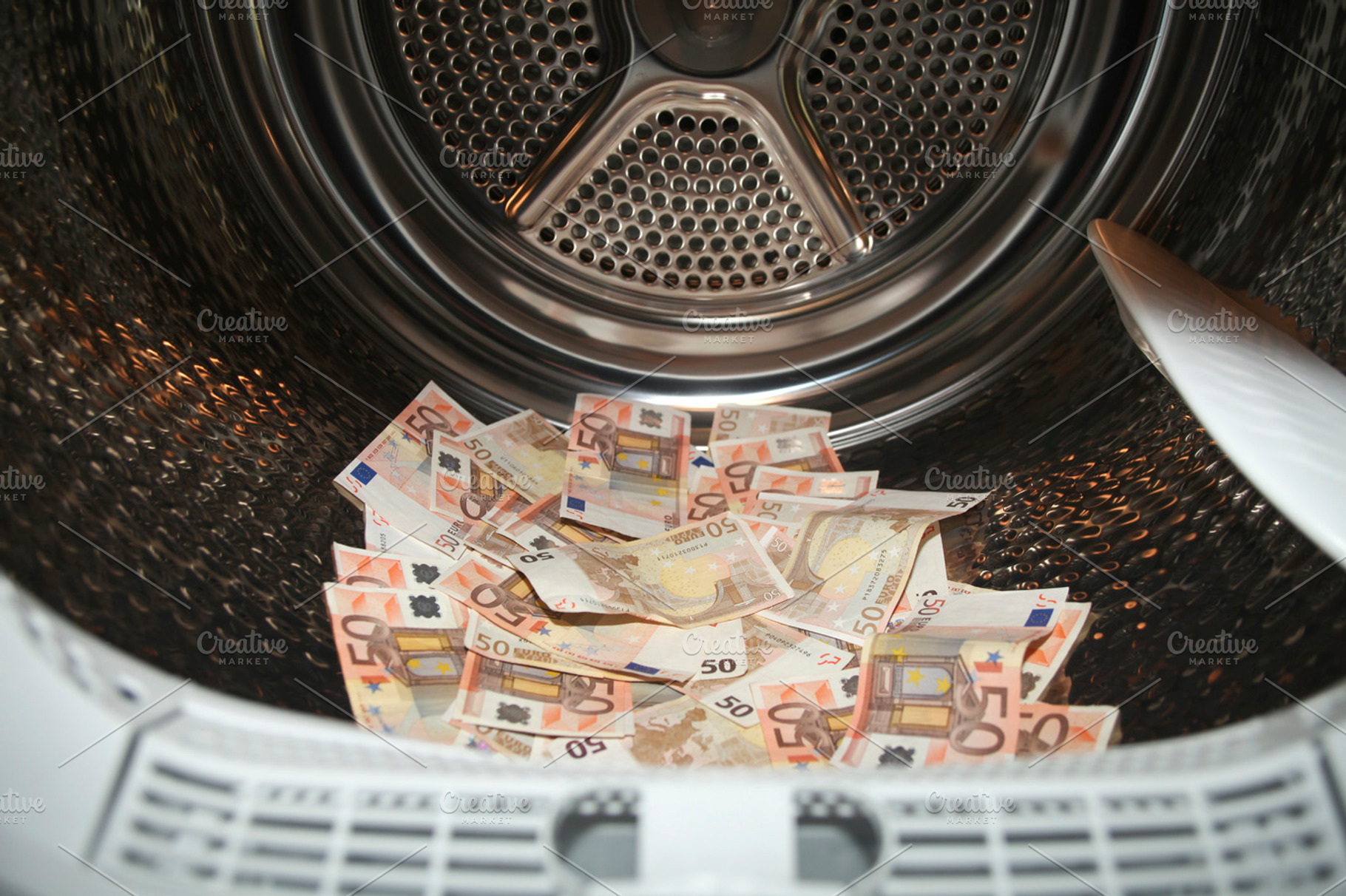 Money laundering in washer containing banknotes, cash, and conceptual