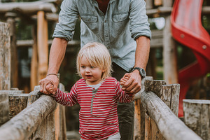 Father and toddler son walking woode, a Photo by Pixeness Studio